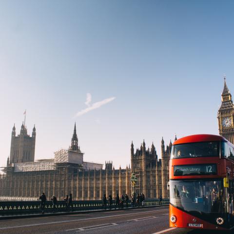 A red bus driving over Westminster Bridge.